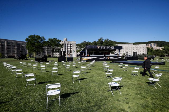 Tables are spread apart on the grass of the academy